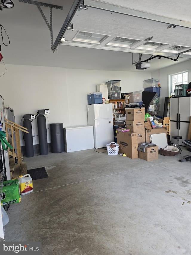 garage with a garage door opener and freestanding refrigerator