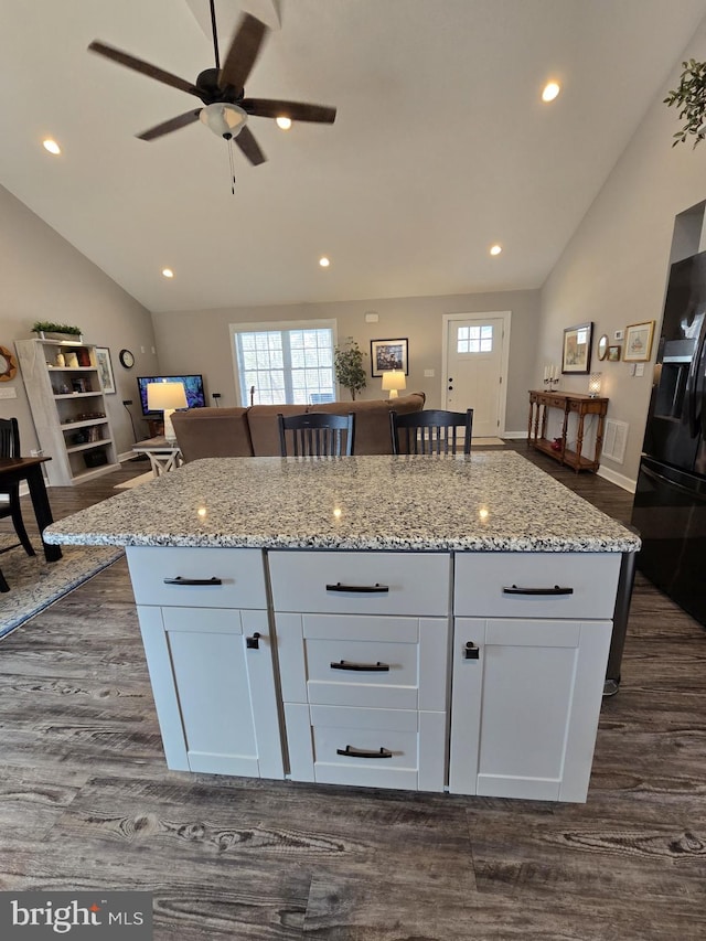 kitchen featuring light stone counters, dark wood-style flooring, white cabinets, and black refrigerator with ice dispenser