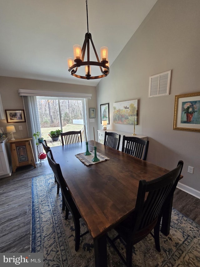 dining room with visible vents, baseboards, dark wood finished floors, lofted ceiling, and an inviting chandelier