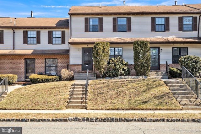 townhome / multi-family property featuring fence and brick siding