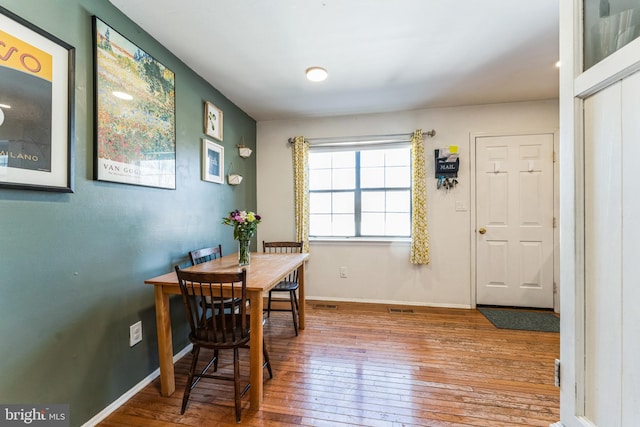 dining area featuring baseboards and hardwood / wood-style flooring