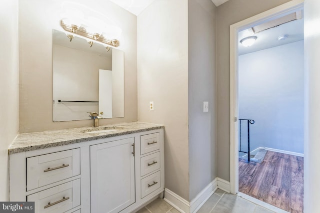 bathroom with baseboards, vanity, and tile patterned flooring