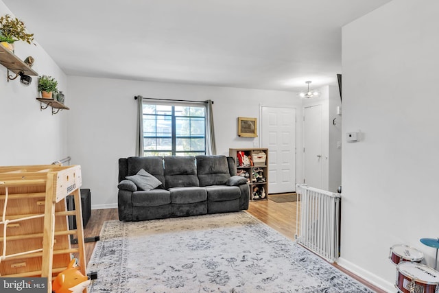 living room with a notable chandelier, wood finished floors, and baseboards