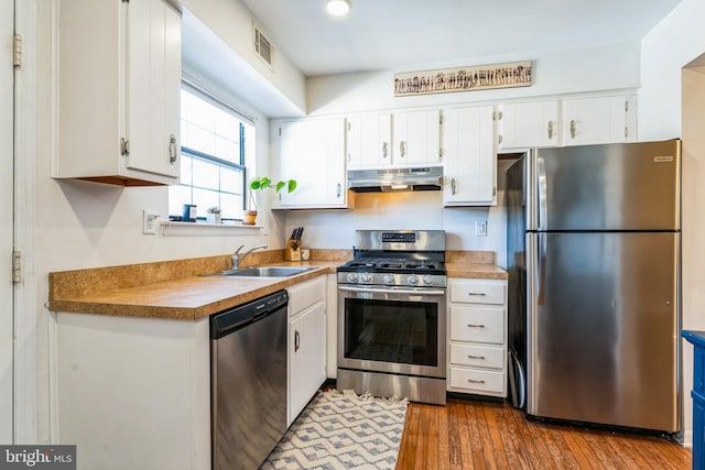 kitchen with under cabinet range hood, visible vents, appliances with stainless steel finishes, and white cabinetry