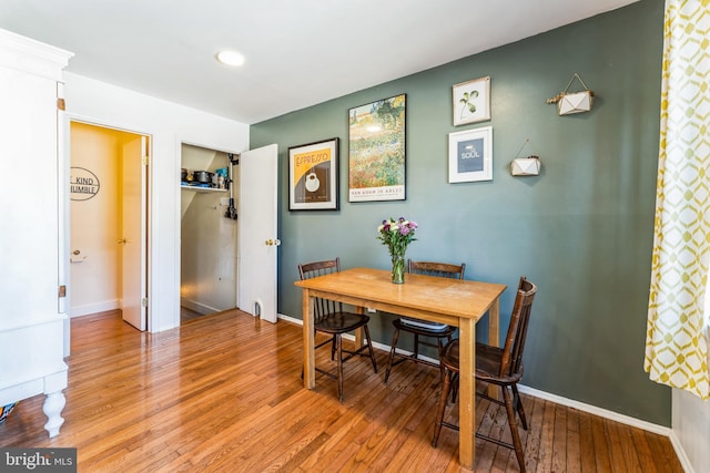 dining space featuring light wood-style flooring and baseboards