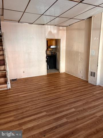 basement featuring stairway, wood finished floors, and visible vents