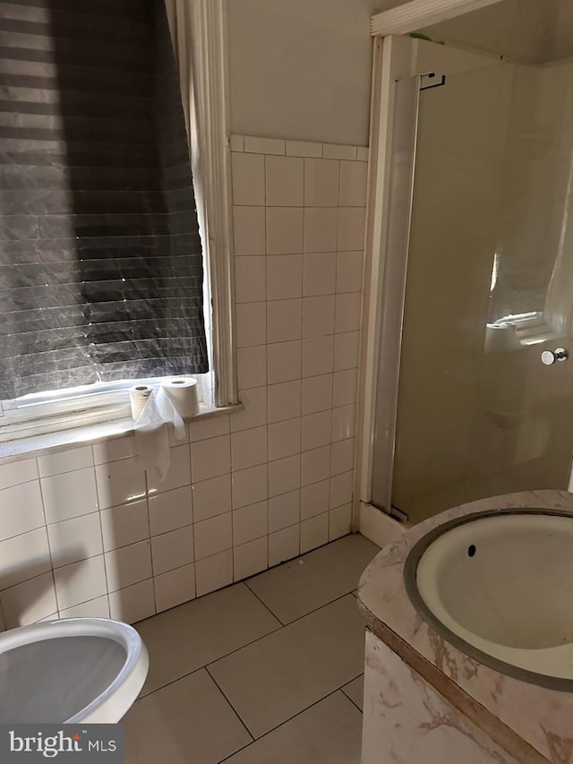 full bathroom featuring tile patterned flooring, a stall shower, and tile walls