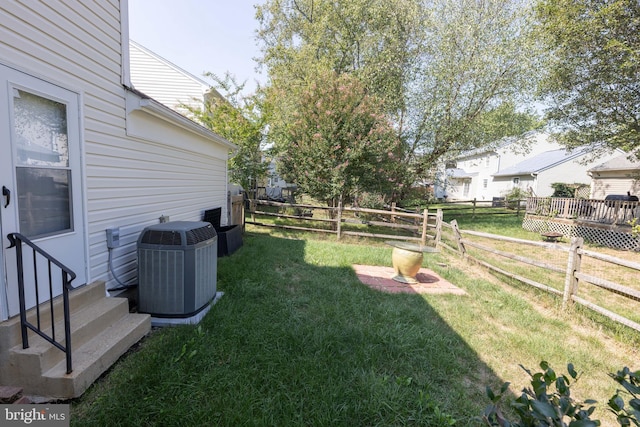 view of yard featuring central AC unit, entry steps, and fence private yard