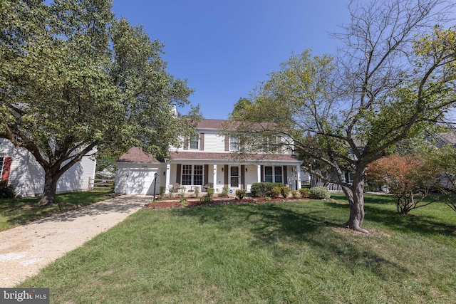 view of front of property with a front lawn, concrete driveway, covered porch, and an attached garage