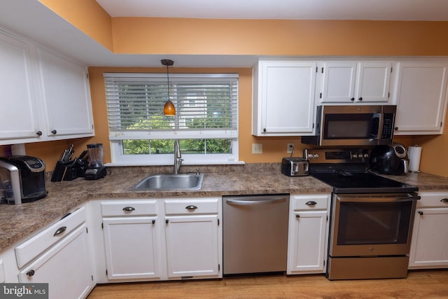 kitchen featuring a sink, appliances with stainless steel finishes, and white cabinetry