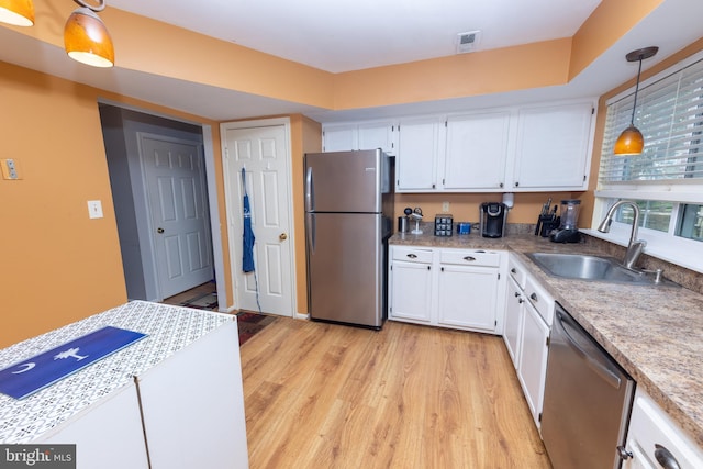 kitchen with visible vents, a sink, light wood-style floors, appliances with stainless steel finishes, and white cabinetry