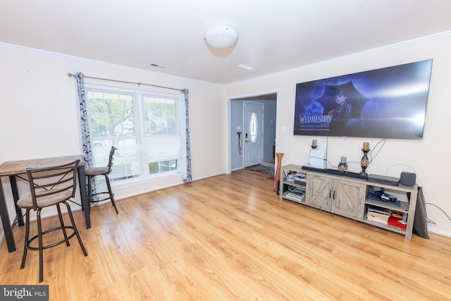 living area featuring light wood-type flooring, baseboards, visible vents, and ornamental molding