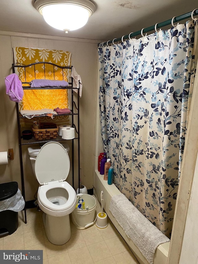 bathroom with tile patterned floors, shower / bath combination with curtain, and toilet