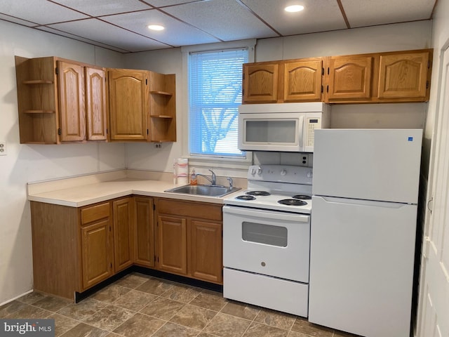 kitchen featuring open shelves, a drop ceiling, a sink, white appliances, and light countertops