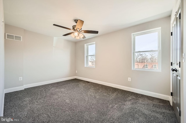 unfurnished room with visible vents, baseboards, a ceiling fan, and dark carpet