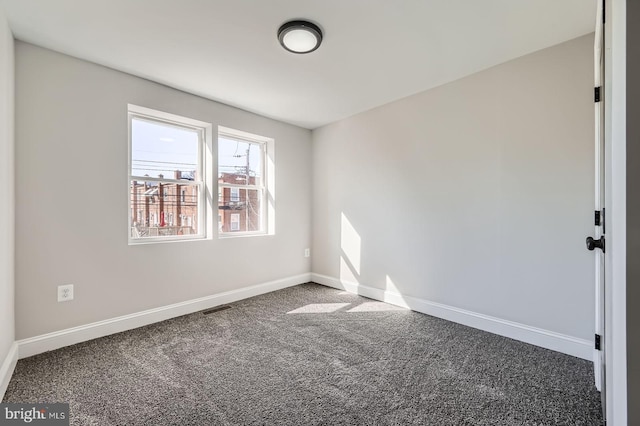 empty room with visible vents, baseboards, and carpet