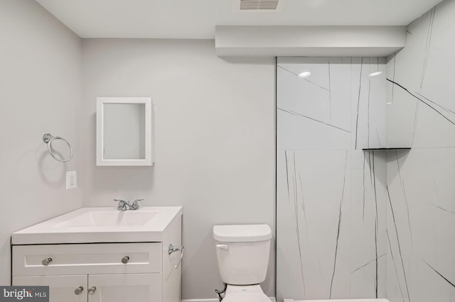 bathroom featuring vanity, toilet, and visible vents