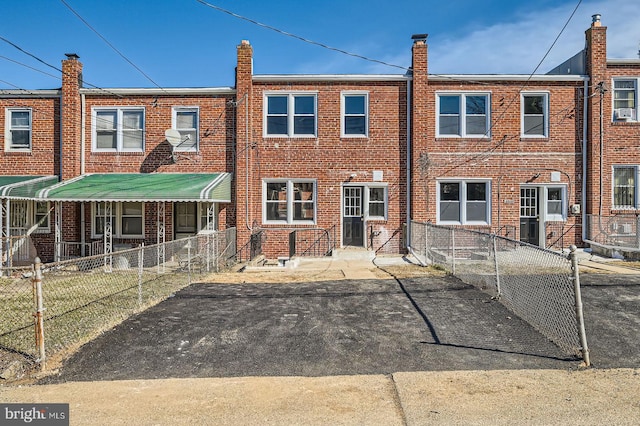 rear view of house with brick siding and fence