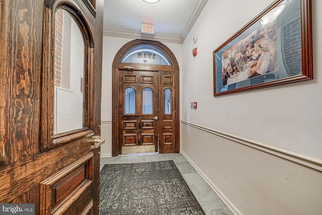 foyer featuring marble finish floor, crown molding, and baseboards