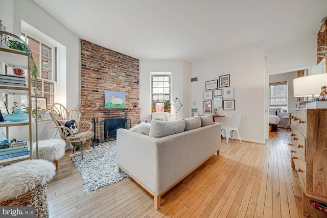 living area with visible vents, light wood-style floors, and a fireplace