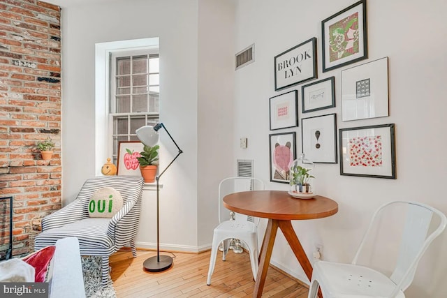 sitting room with visible vents, baseboards, and hardwood / wood-style floors