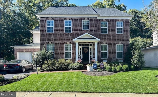 view of front of home with a garage, brick siding, and a front yard