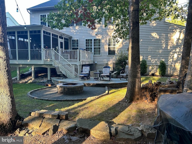 back of property featuring stairway, an outdoor fire pit, a patio, and a sunroom