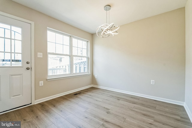 entrance foyer featuring visible vents, wood finished floors, baseboards, and a chandelier