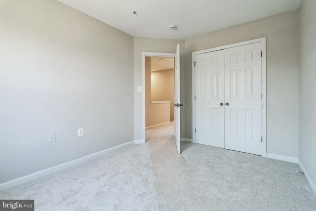 unfurnished bedroom with a closet, carpet, and baseboards