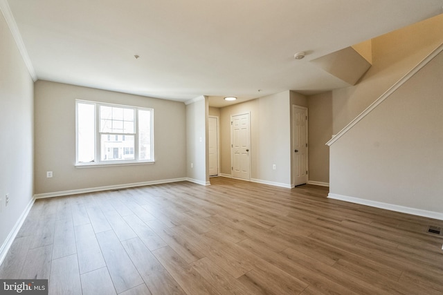 empty room with visible vents, wood finished floors, and baseboards