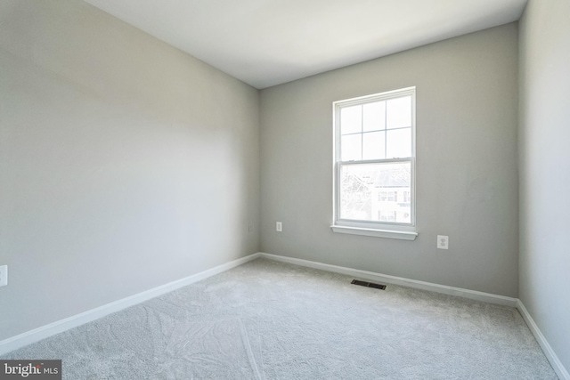 unfurnished room with visible vents, carpet flooring, and baseboards