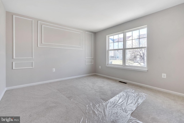 carpeted empty room with visible vents and baseboards