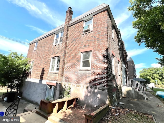 view of side of property with brick siding and a chimney