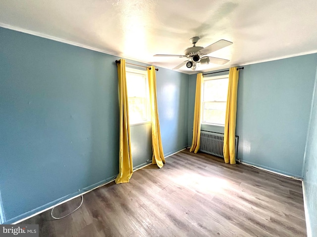 unfurnished bedroom with a ceiling fan, wood finished floors, baseboards, radiator heating unit, and ornamental molding