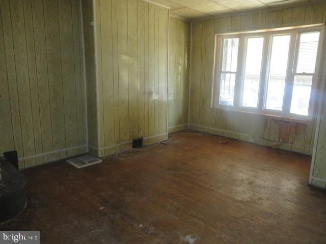 spare room with wooden walls and wood finished floors