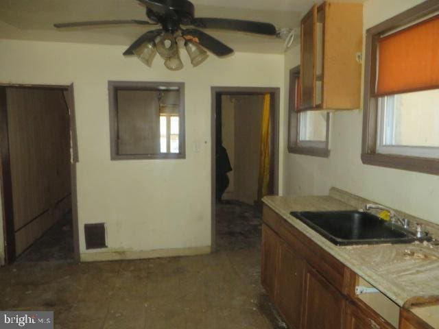 kitchen with light countertops, a ceiling fan, visible vents, and a sink