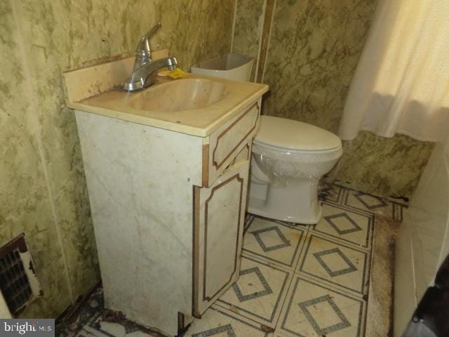 bathroom with vanity, toilet, and visible vents