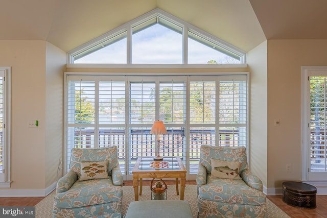 sitting room with baseboards and lofted ceiling