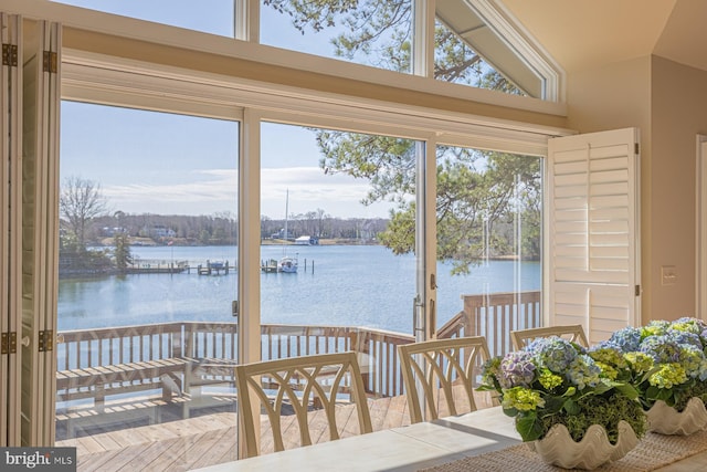 sunroom / solarium featuring vaulted ceiling and a water view