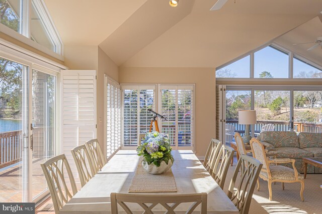 sunroom featuring vaulted ceiling, a ceiling fan, and a healthy amount of sunlight