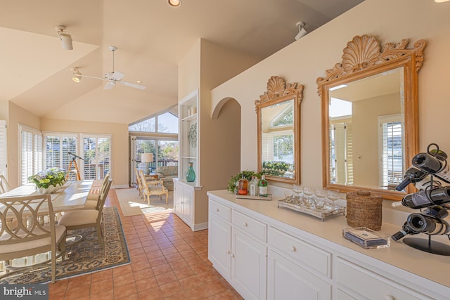 interior space with tile patterned floors, ceiling fan, and vaulted ceiling