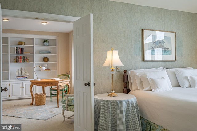 bedroom featuring light carpet and wallpapered walls