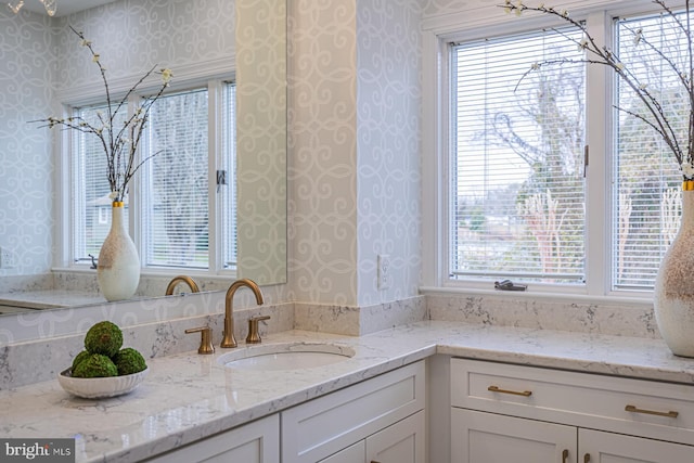 bathroom featuring vanity and wallpapered walls