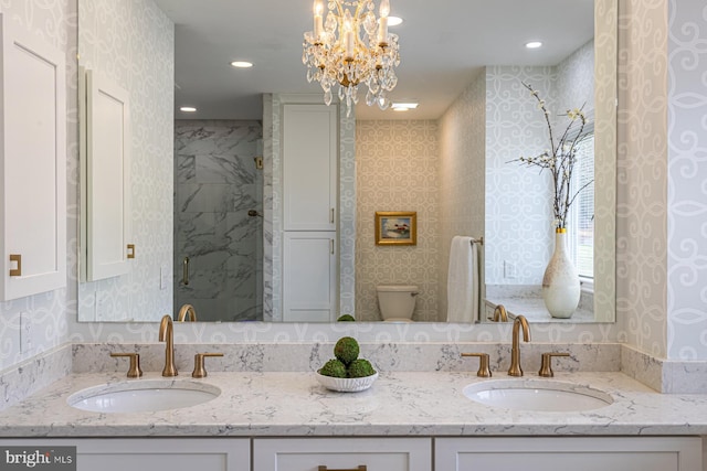 full bath with double vanity, wallpapered walls, and a sink