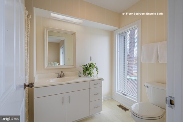 bathroom with visible vents, a healthy amount of sunlight, toilet, and vanity