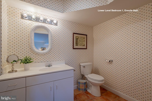 bathroom with tile patterned floors, toilet, wallpapered walls, baseboards, and vanity