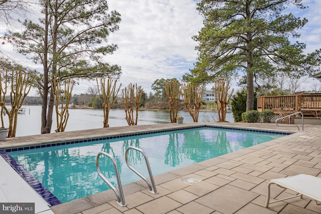 outdoor pool with a patio and a deck with water view