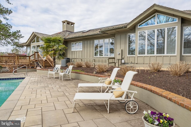 view of patio / terrace featuring a fenced in pool, central air condition unit, and a deck