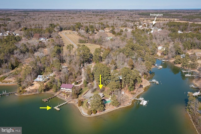 birds eye view of property featuring a forest view and a water view