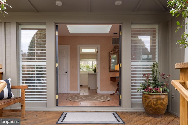 foyer featuring visible vents, light wood-style flooring, and a skylight